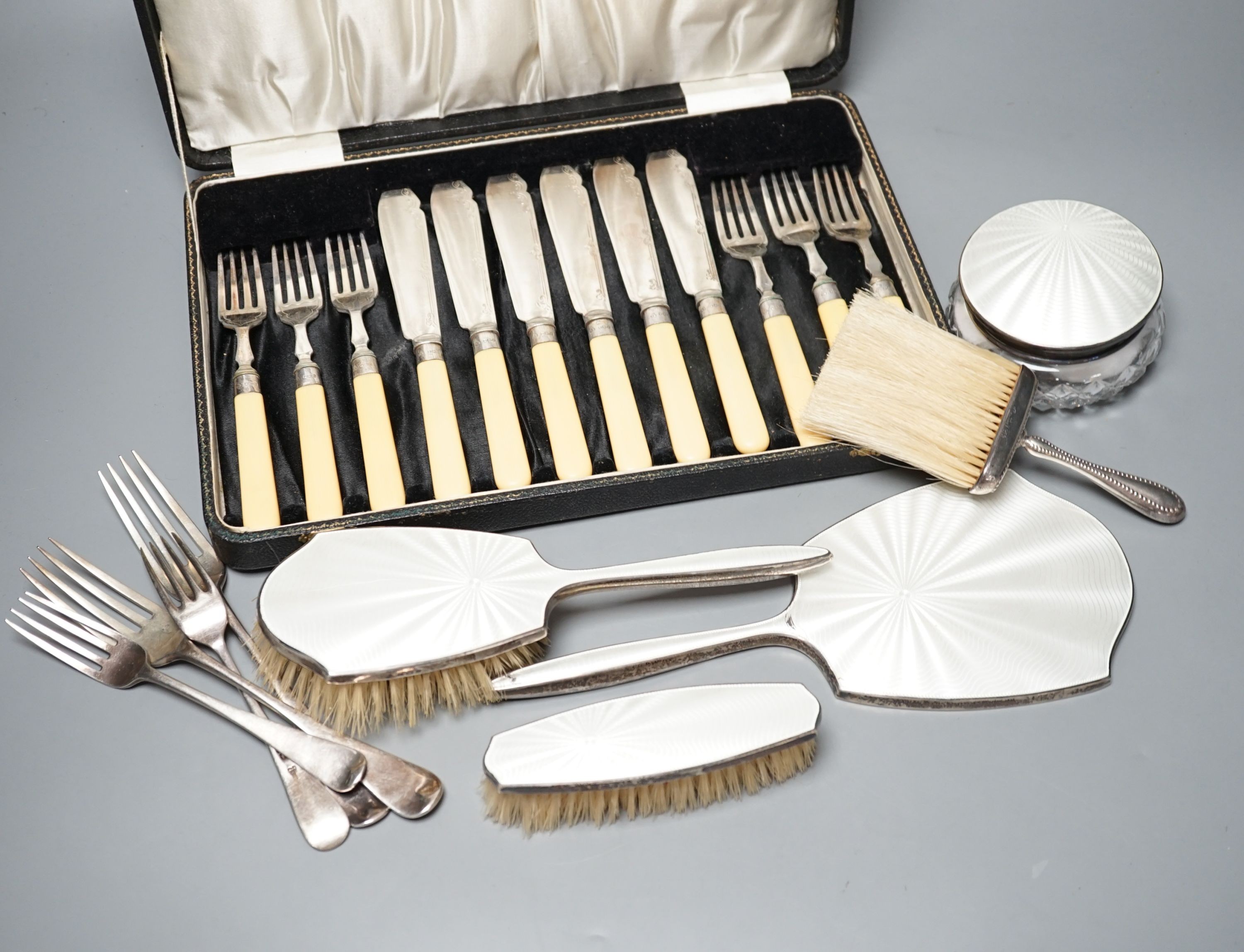 A mixed collection of sundry English silver to include unboxed flatware, a cased set silver teaspoons with tongs, further boxed cutlery including plated a four piece silver and enamel mounted glass dressing table set (en